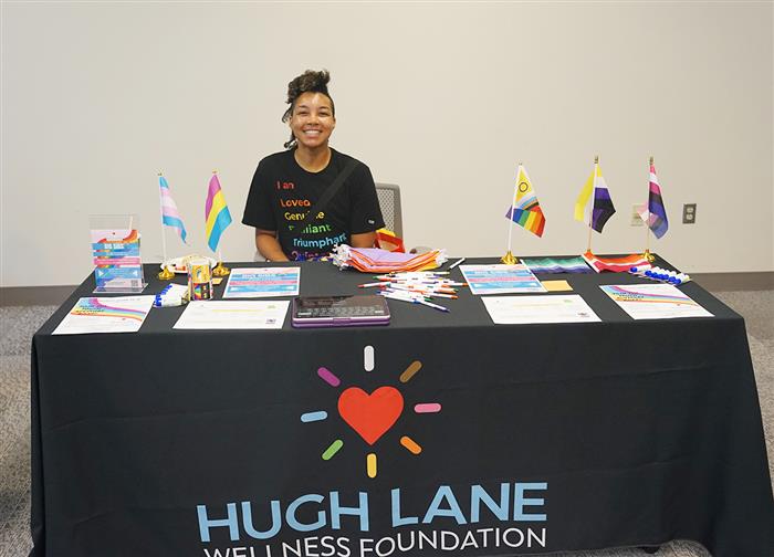 A woman from the Hugh Lane Wellness Foundation sits at her table during a vendor fair